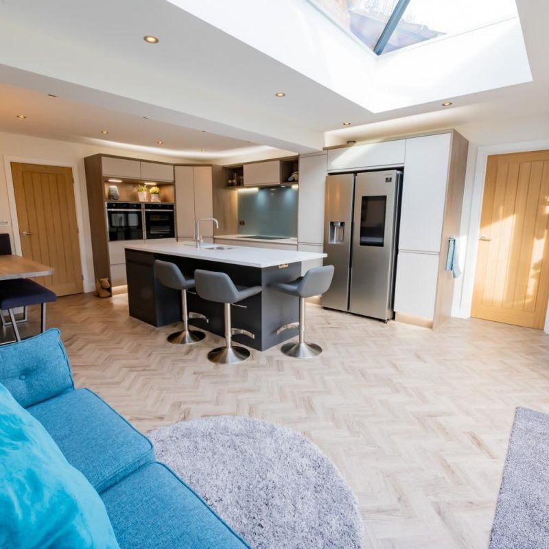 A kitchen that has been fully renovated including a smart fridge and a Tv.